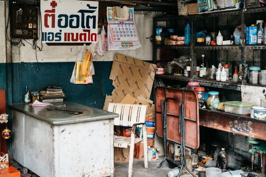A cluttered garage workshop with various tools, shelves, a desk, and visible clutter.